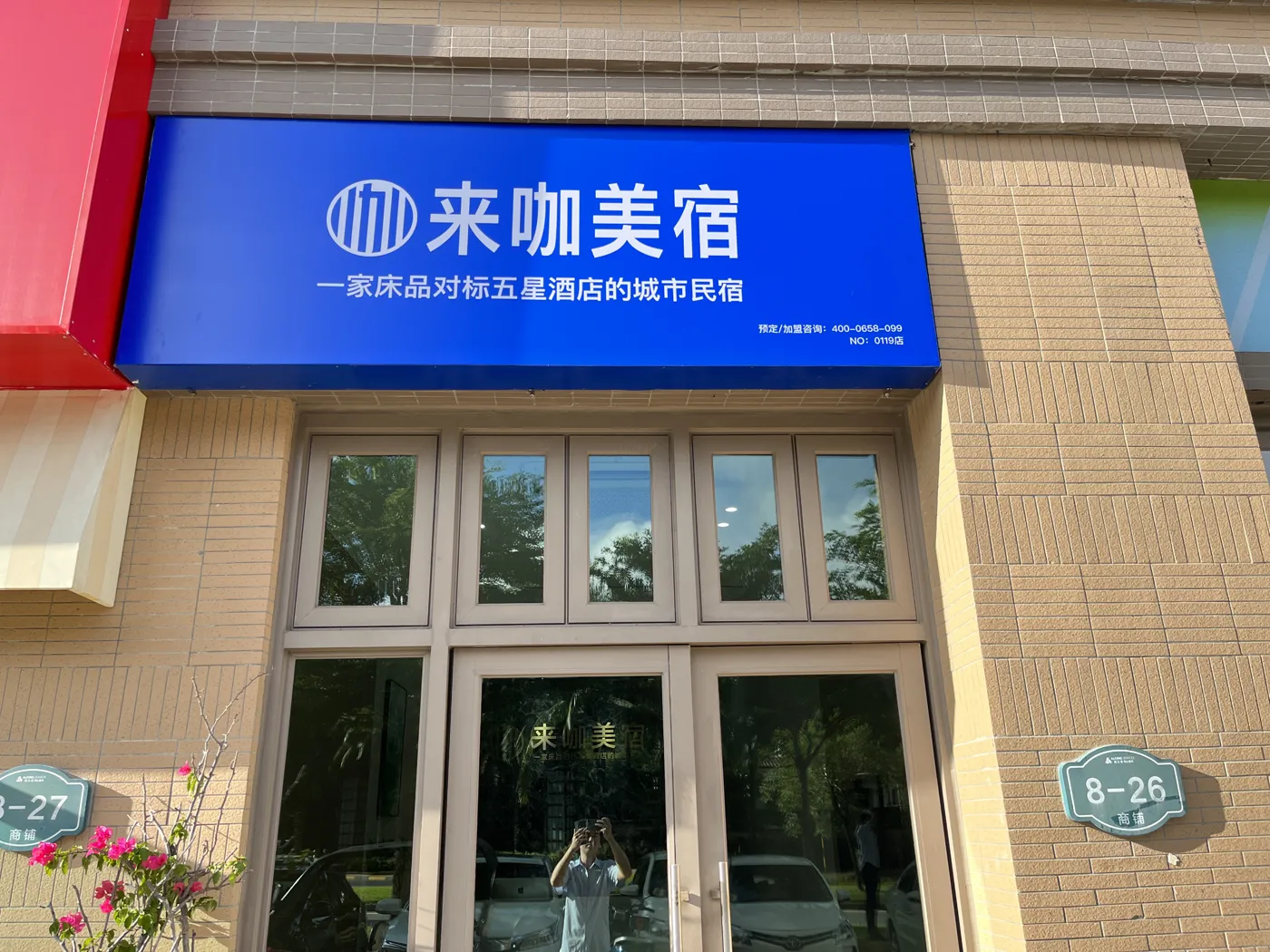 来咖美宿清水湾阿罗哈店 门店门头实拍，蓝色来咖美宿招牌与街铺门牌